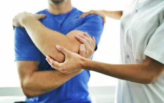 Physiotherapist Doing Treatment With Patient In Bright Office