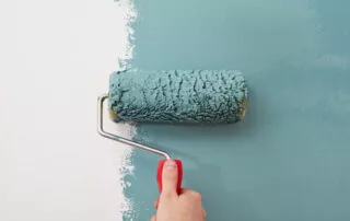 Male Hand Painting Wall With Paint Roller