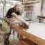 Carpenter Working With Electric Planer On Wooden Plank In Workshop. Craftsman Makes Own Successful Small Business.